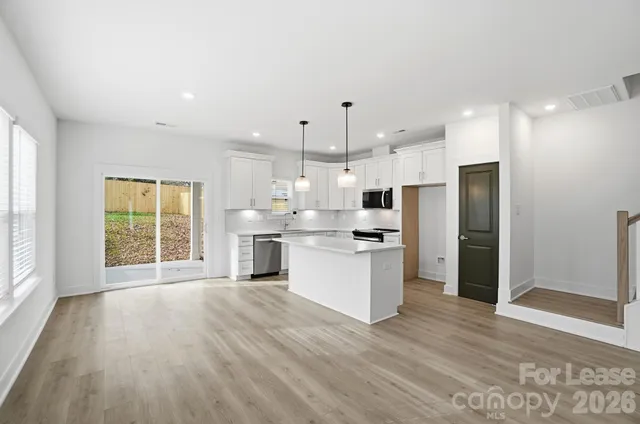 a view of a kitchen with wooden floor and a window