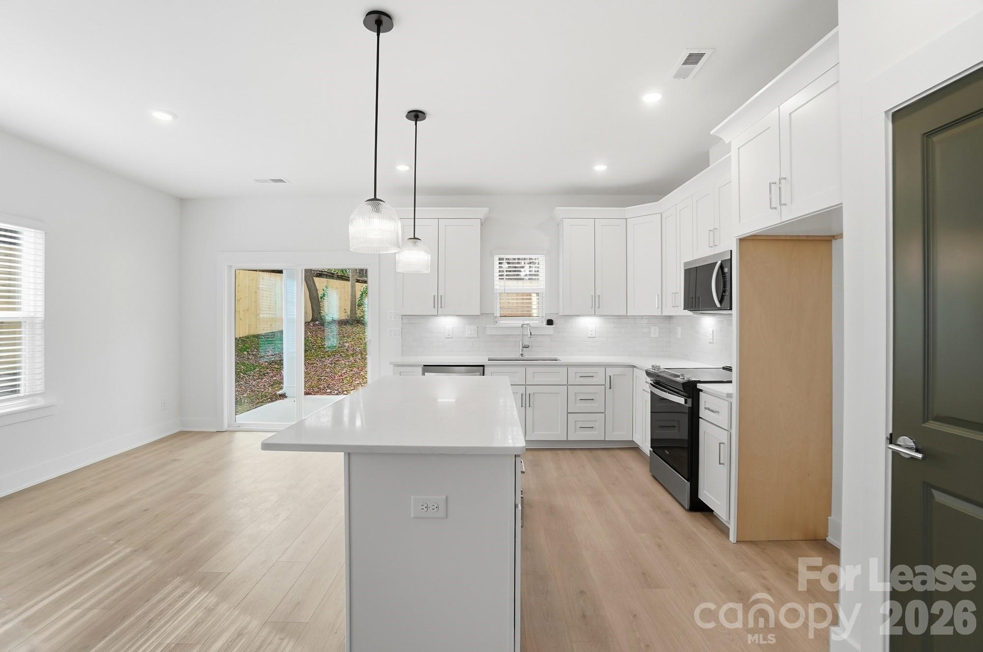 3941 Tillman Road Charlotte, NC 28208 - Photo 15 of 48 a large kitchen with granite countertop a large counter top a sink stainless steel appliances and cabinets