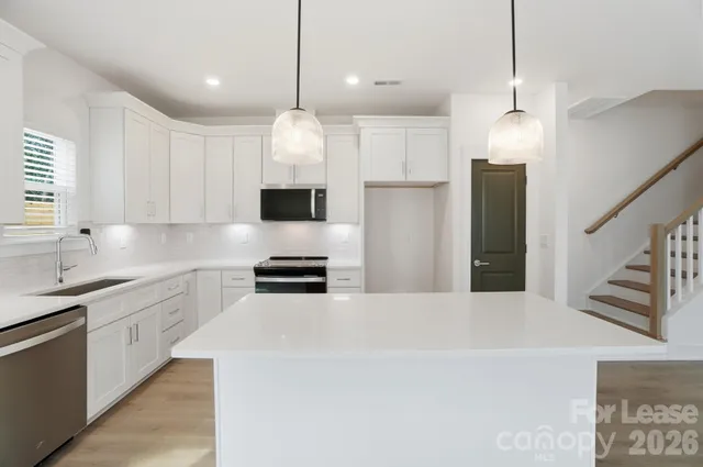 a kitchen with stainless steel appliances white cabinets and a sink