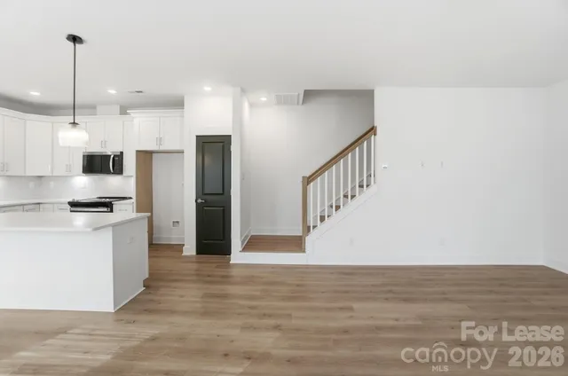 a view of hallway with cabinets and wooden floor