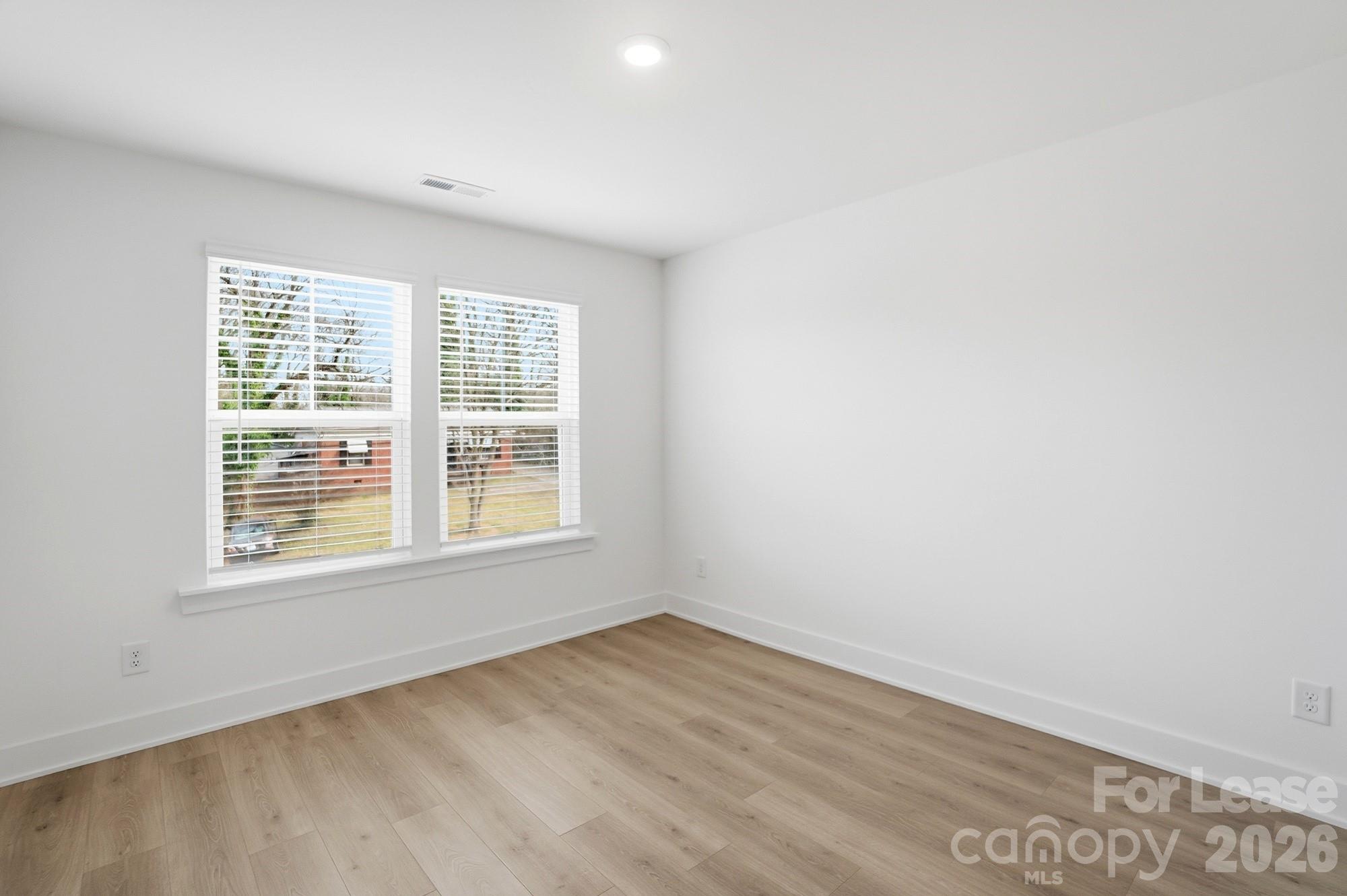 3941 Tillman Road Charlotte, NC 28208 - Photo 37 of 48 an empty room with wooden floor and windows
