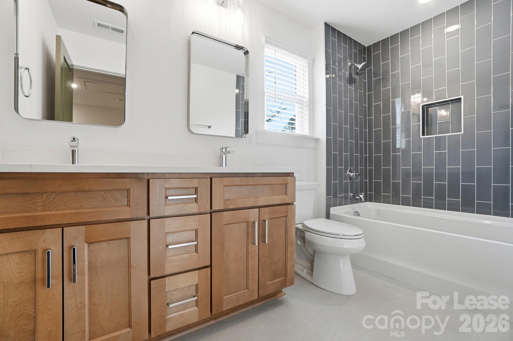 3941 Tillman Road Charlotte, NC 28208 - Photo 39 of 48 a bathroom with a toilet a sink a mirror a bathtub and vanity