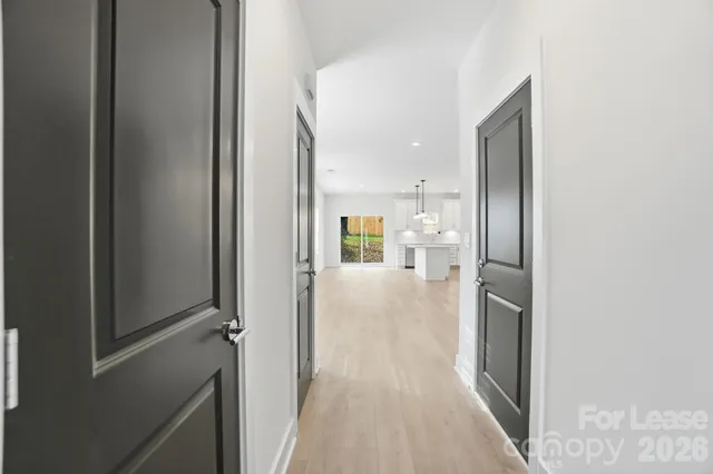 a view of a hallway with wooden floor