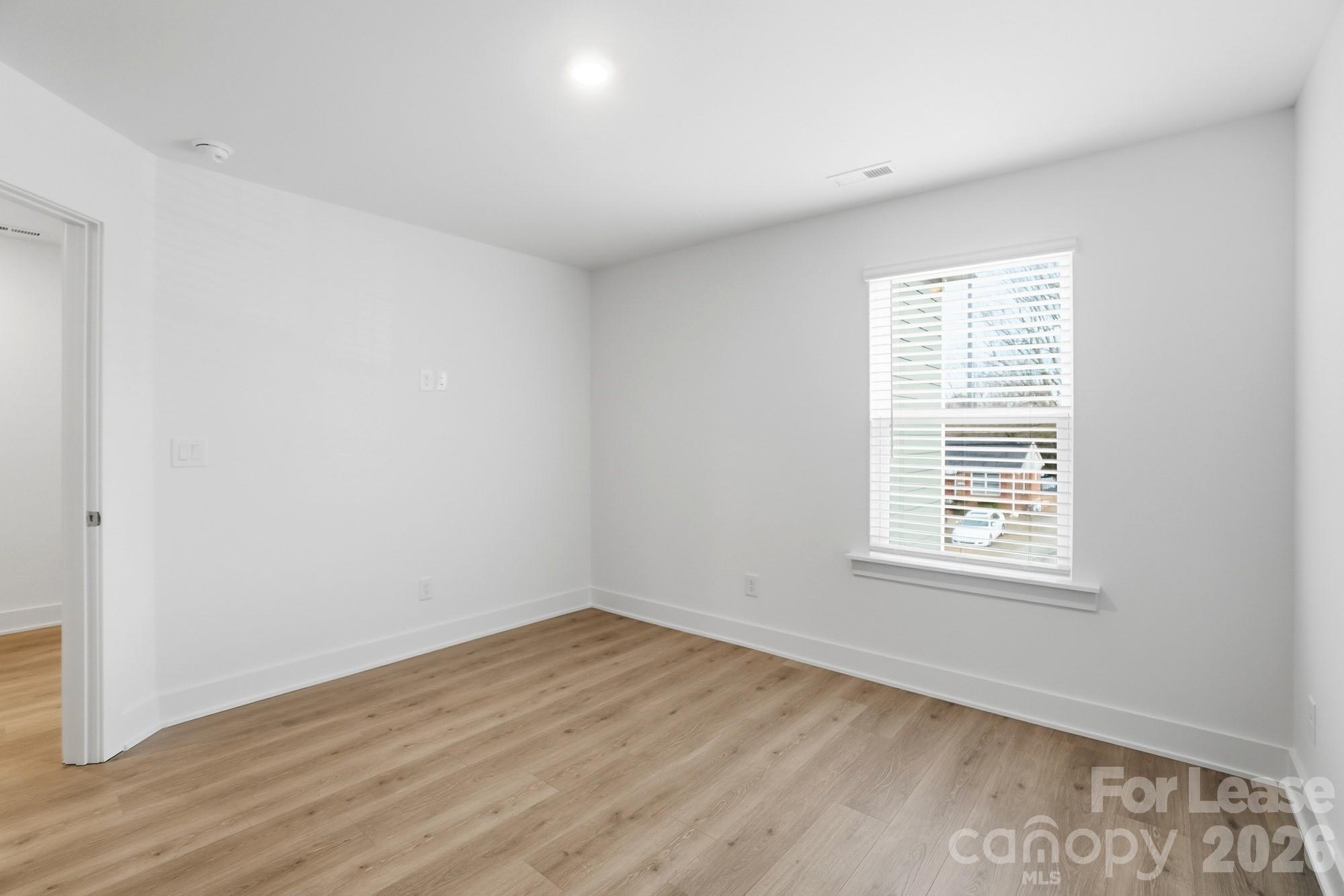 3941 Tillman Road Charlotte, NC 28208 - Photo 42 of 48 a view of an empty room with wooden floor and a window