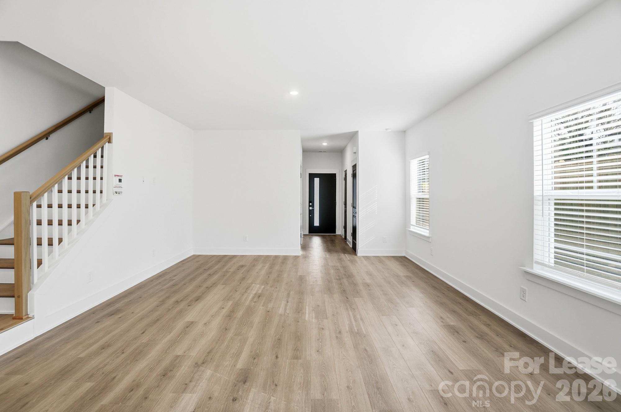 3941 Tillman Road Charlotte, NC 28208 - Photo 9 of 48 a view of an empty room with wooden floor and windows
