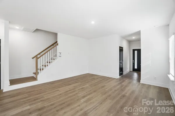 a large white kitchen with wooden floors and white walls