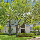 a front view of a house with a yard and trees