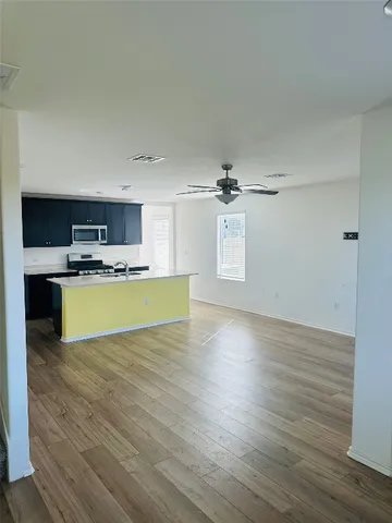 a view of kitchen with wooden floor electronic appliances and window