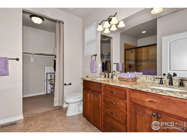 a bathroom with a granite countertop sink toilet a large mirror and shower