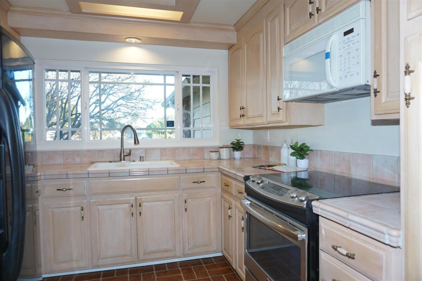 580 Pomeroy Avenue Santa Clara, CA 95051 - Photo 5 of 15 a kitchen with stainless steel appliances white cabinets and a window