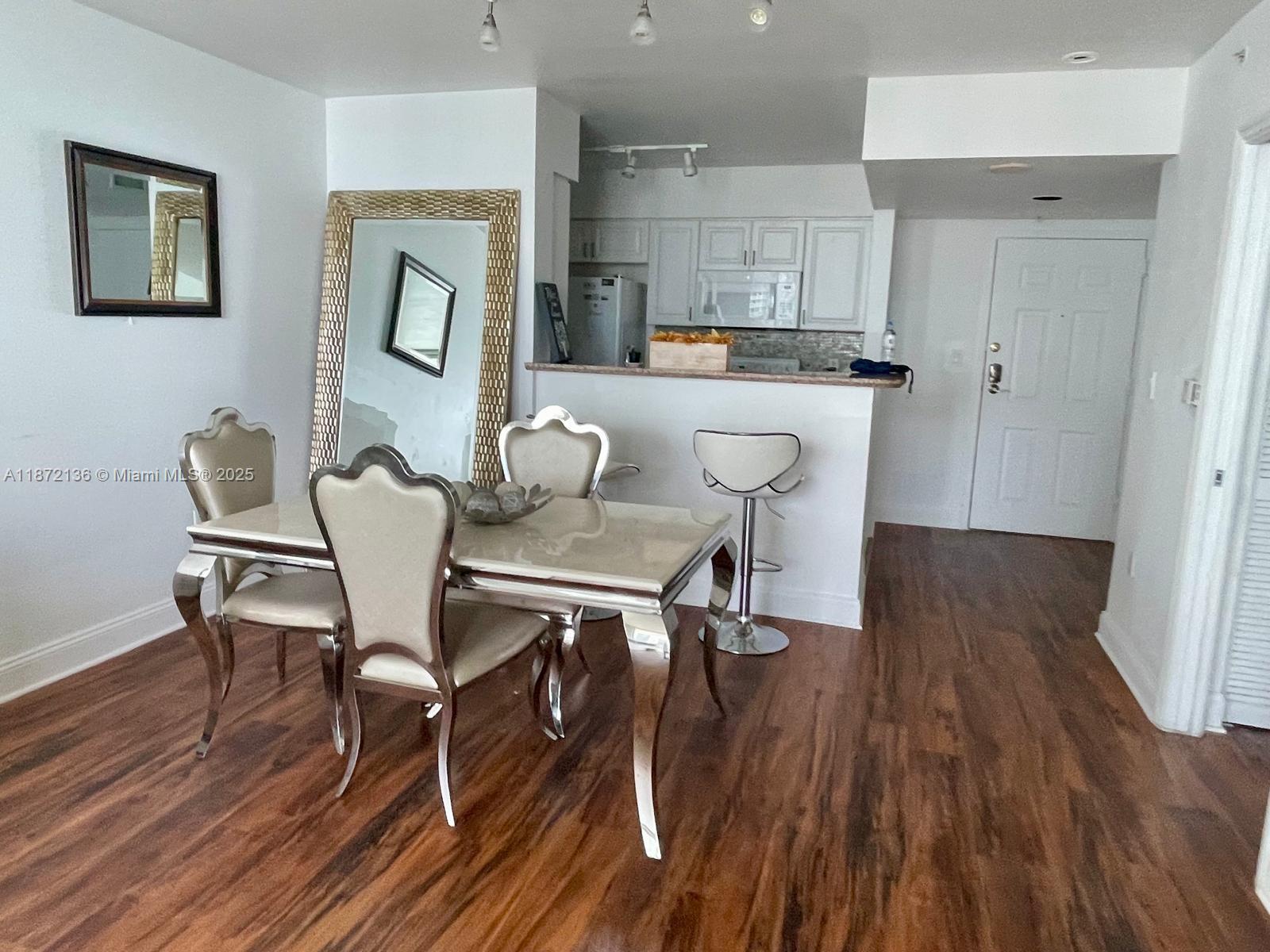 1155 Brickell Bay Drive, Unit 1805 Miami, FL 33131 - Photo 4 of 11 a dining room with furniture and wooden floor