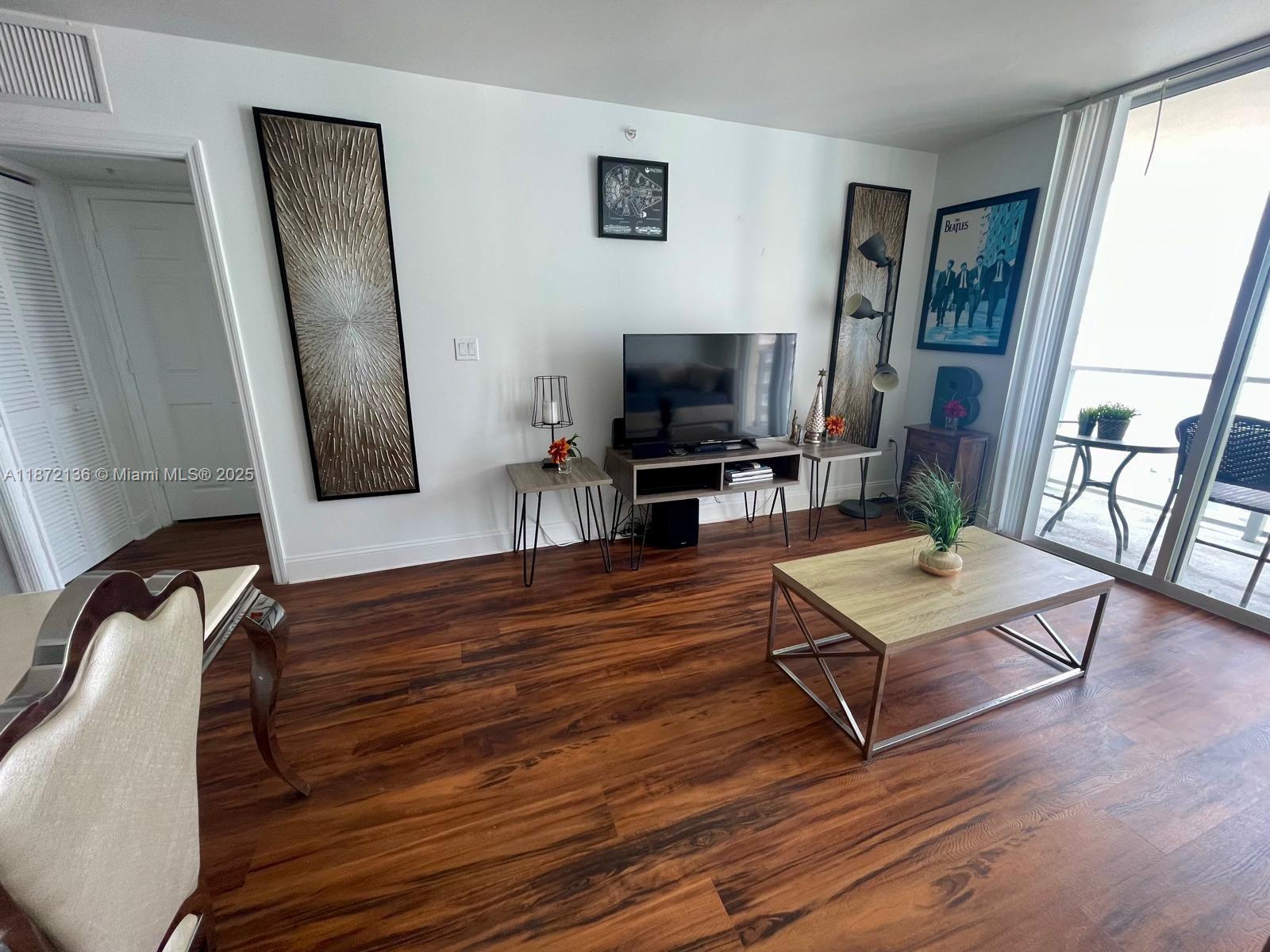 1155 Brickell Bay Drive, Unit 1805 Miami, FL 33131 - Photo 6 of 11 a living room with furniture flat screen tv and wooden floor