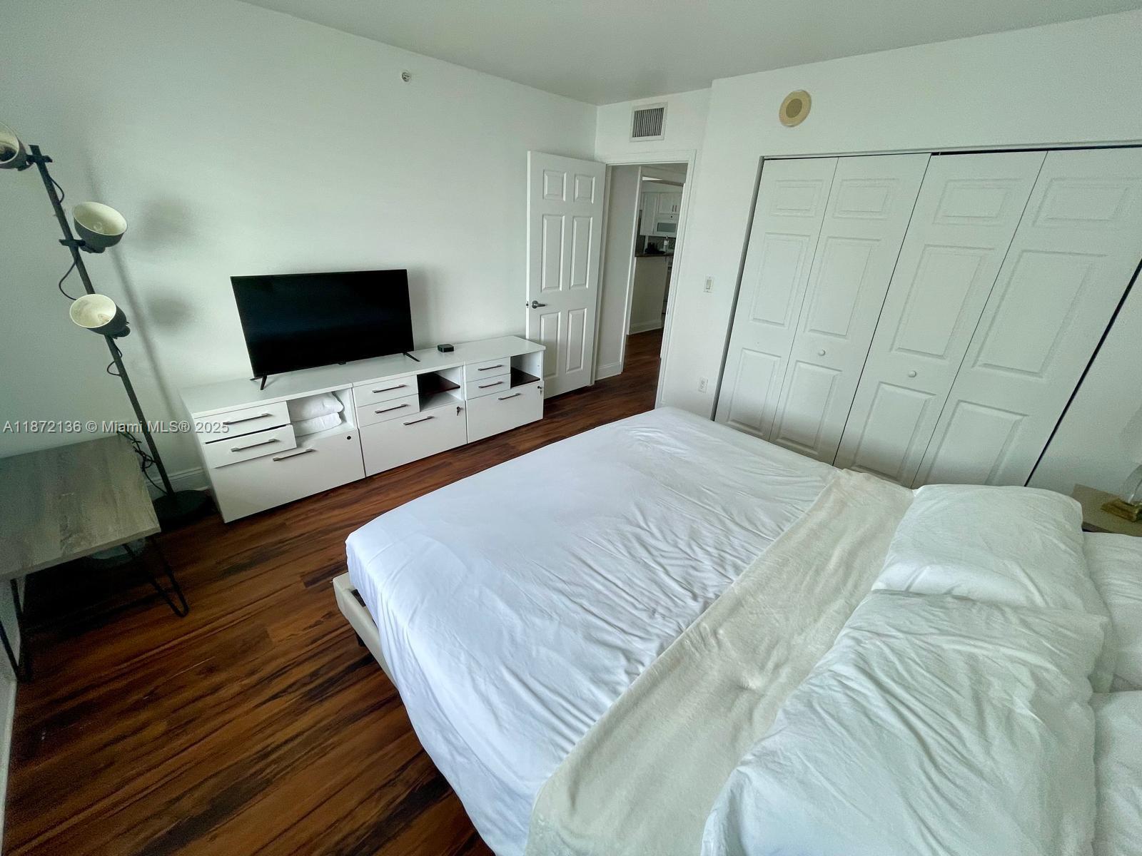 1155 Brickell Bay Drive, Unit 1805 Miami, FL 33131 - Photo 7 of 11 a bedroom with a bed and a flat screen tv