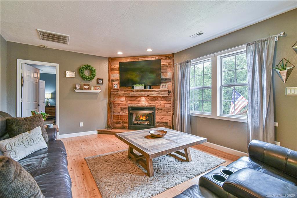 90 Devlin Street Canton, NC 28716 - Photo 11 of 25 a living room with furniture a flat screen tv and a large window