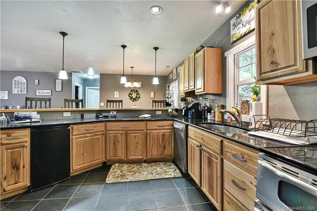 90 Devlin Street Canton, NC 28716 - Photo 13 of 25 a kitchen with stainless steel appliances granite countertop a sink a stove and a wooden floors