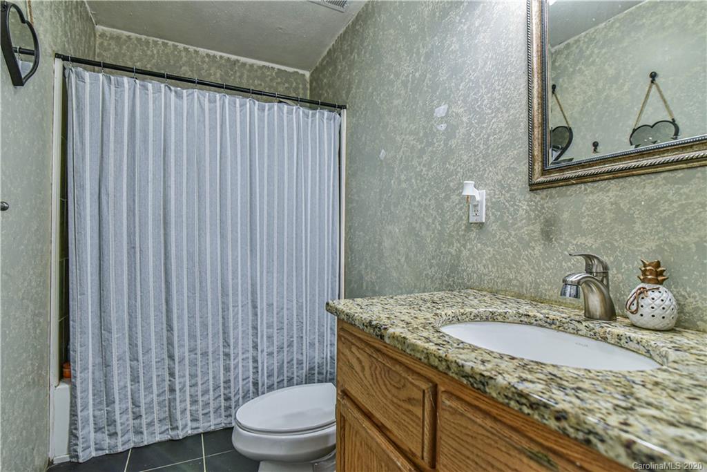 90 Devlin Street Canton, NC 28716 - Photo 23 of 25 a bathroom with a granite countertop sink toilet and mirror