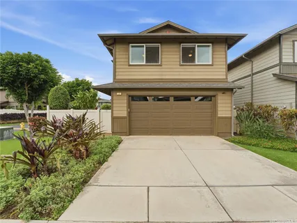 a front view of a house with a yard and potted plants