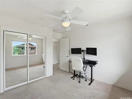 a view of a workspace with furniture and a window