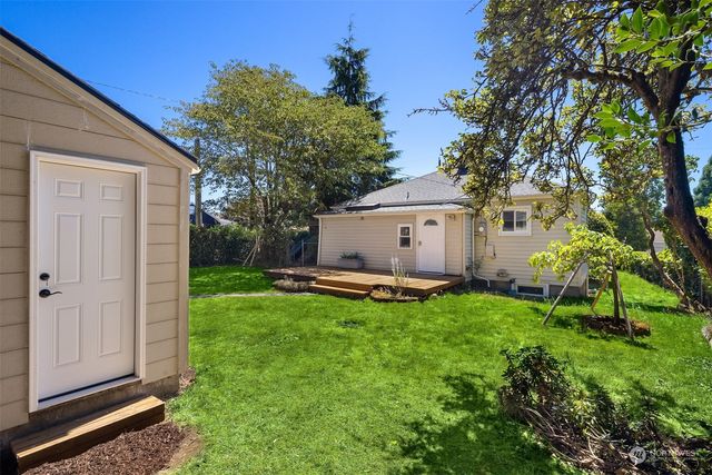 a view of a backyard with potted plants and large trees