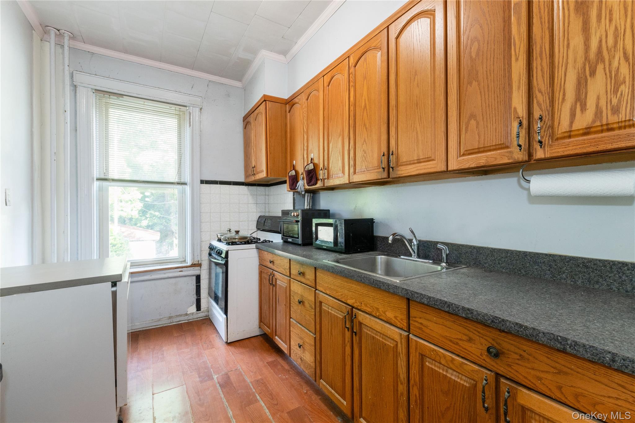 82-72 88th Place Queens, NY 11421 - Photo 5 of 26 a kitchen with stainless steel appliances granite countertop a sink a stove and dishwasher with wooden floor