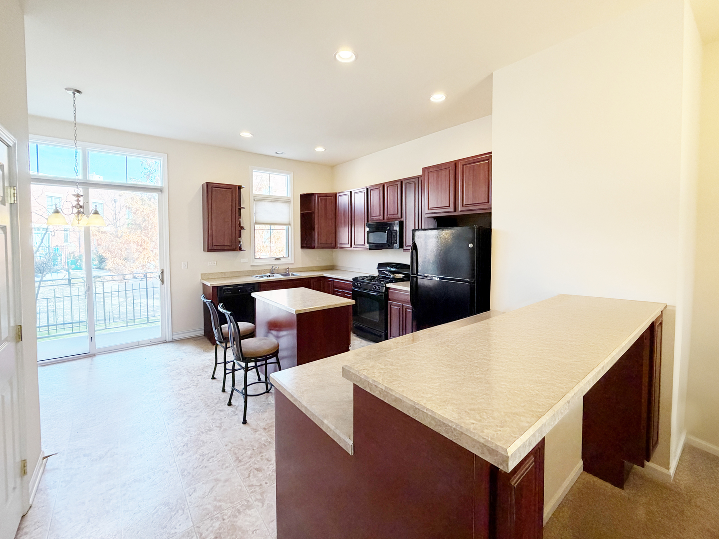 Undisclosed Address Elgin, IL 60120 - Photo 6 of 22 a kitchen with a refrigerator a stove a sink a dining table and chairs