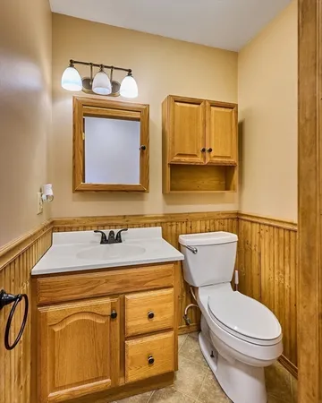 a bathroom with a granite countertop toilet sink and mirror
