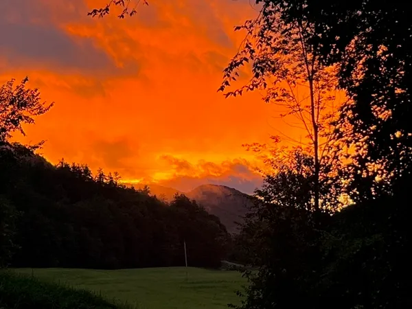 a view of mountain with sunset in background