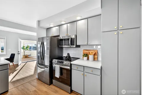 a kitchen with stainless steel appliances a stove microwave and refrigerator