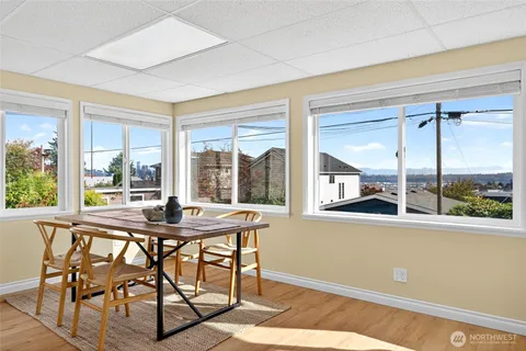 a view of a dining room with furniture large windows and wooden floor