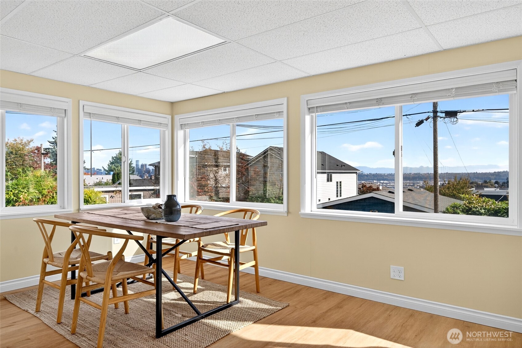 3846 35th Avenue Southwest Seattle, WA 98126 - Photo 16 of 40 a view of a dining room with furniture large windows and wooden floor