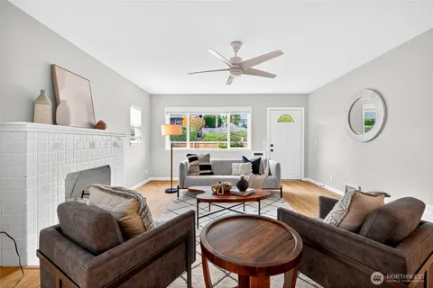a living room with furniture a fireplace and a large window
