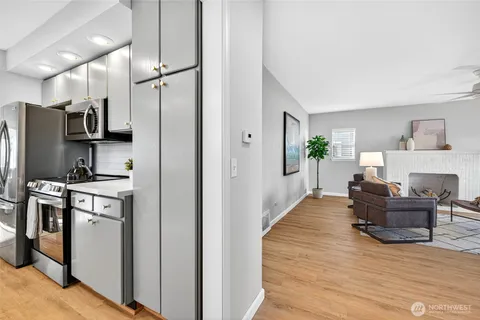 a living room with furniture and a refrigerator