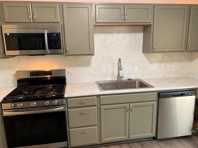 7838 Nimitz Road Millington, TN 38053 - Photo 2 of 14 Kitchen with hardwood / wood-style floors, light stone counters, appliances with stainless steel finishes, and sink