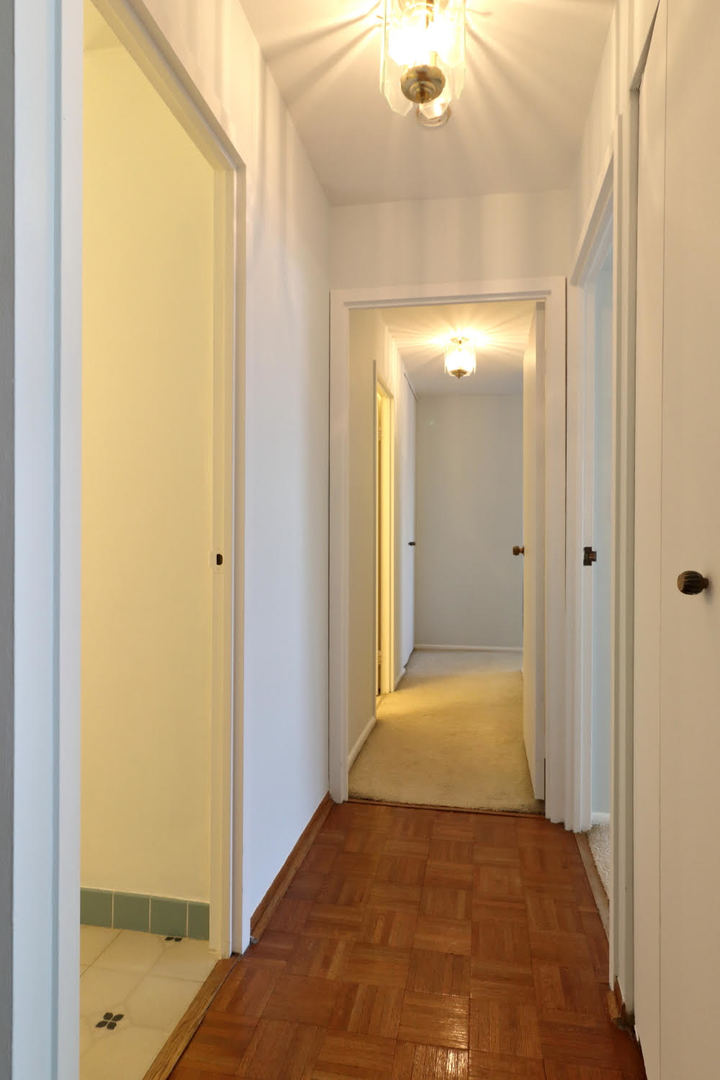 6033 North Sheridan Road, Unit 23F Chicago, IL 60660 - Photo 5 of 30 a view of a hallway with wooden floor and a bathroom