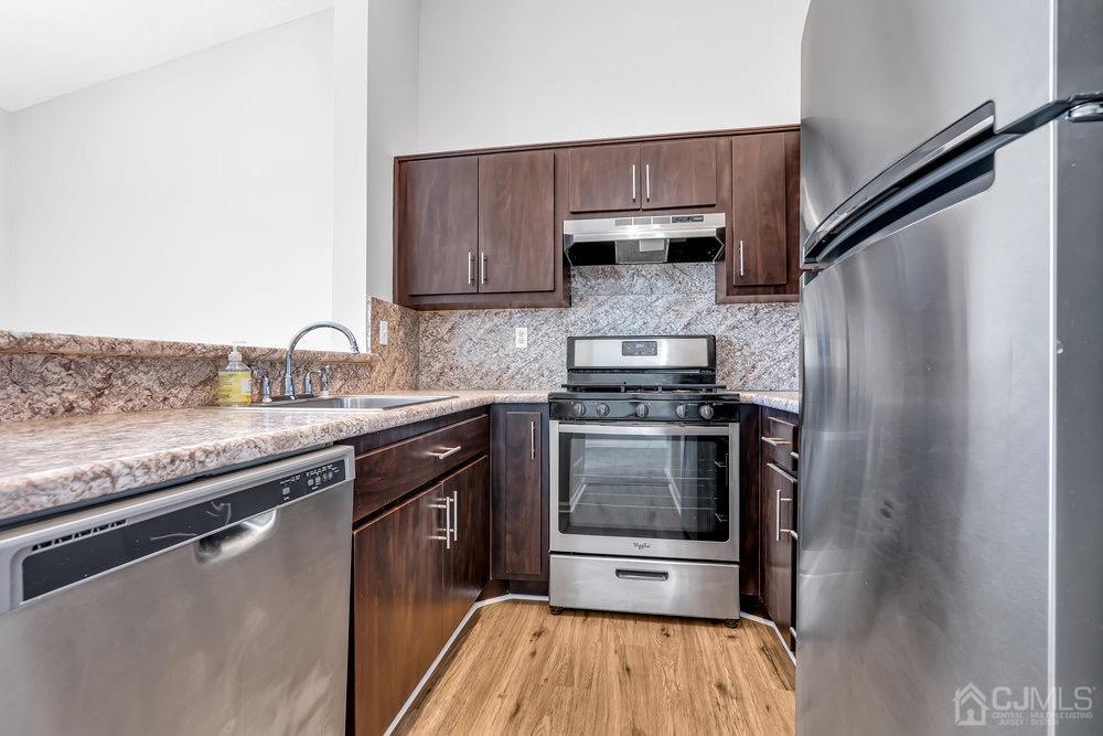 1236 Edpas Road New Brunswick, NJ 08901 - Photo 10 of 26 a kitchen with stainless steel appliances granite countertop a sink stove and refrigerator