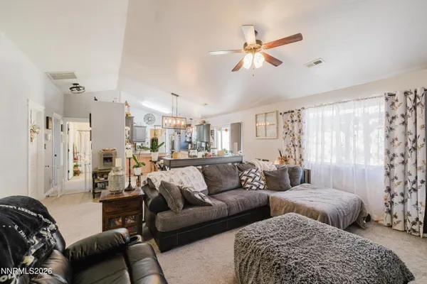a living room with furniture and a ceiling fan