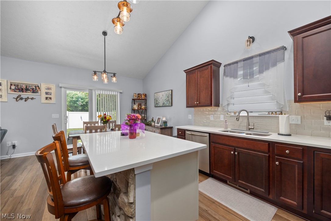 109 West Spring Drive Elyria, OH 44035 - Photo 22 of 46 Modern kitchen featuring a stone-clad island with a white countertop and seating for three
