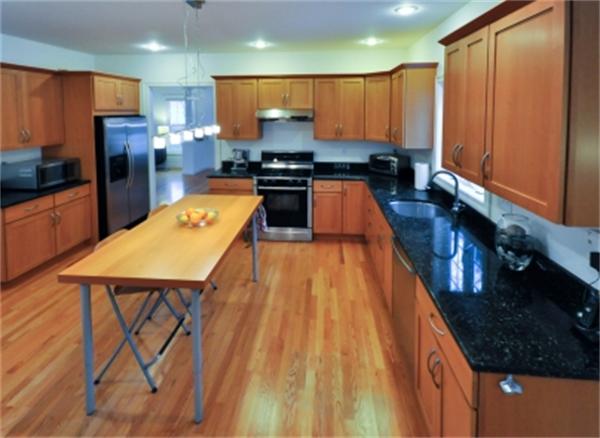5 Squirrel Hill Road Acton, MA 01720 - Photo 12 of 30 a kitchen with kitchen island granite countertop wooden cabinets a refrigerator and a stove