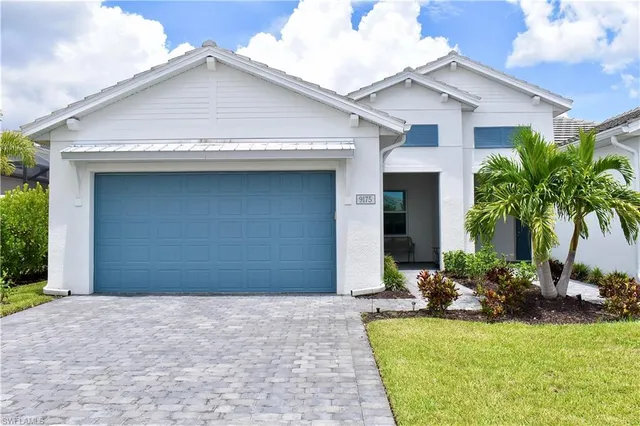 a front view of a house with yard and palm tree