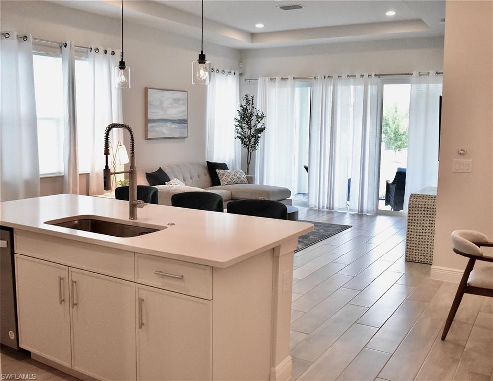 9175 Cayman Drive Naples, FL 34114 - Photo 11 of 31 a kitchen with stainless steel appliances a sink a counter top space and living room view
