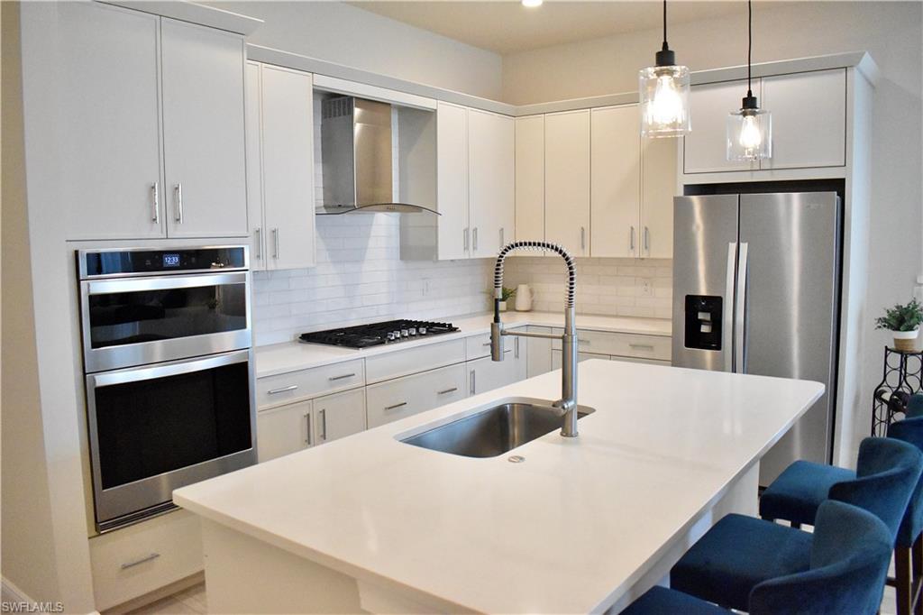 9175 Cayman Drive Naples, FL 34114 - Photo 12 of 31 a kitchen with granite countertop a white stove top oven and sink