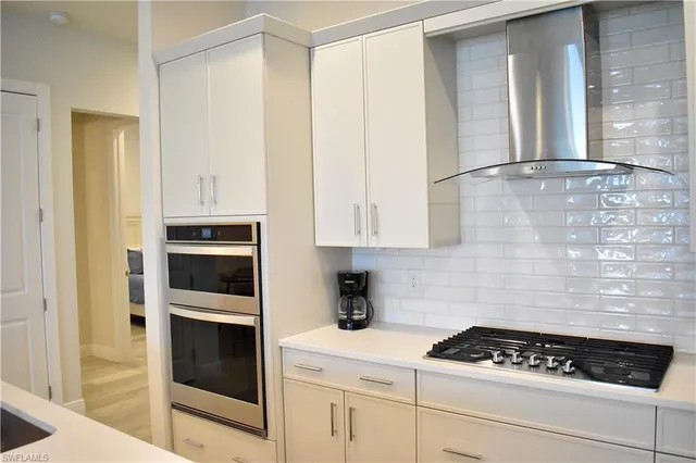 a kitchen with white cabinets and appliances