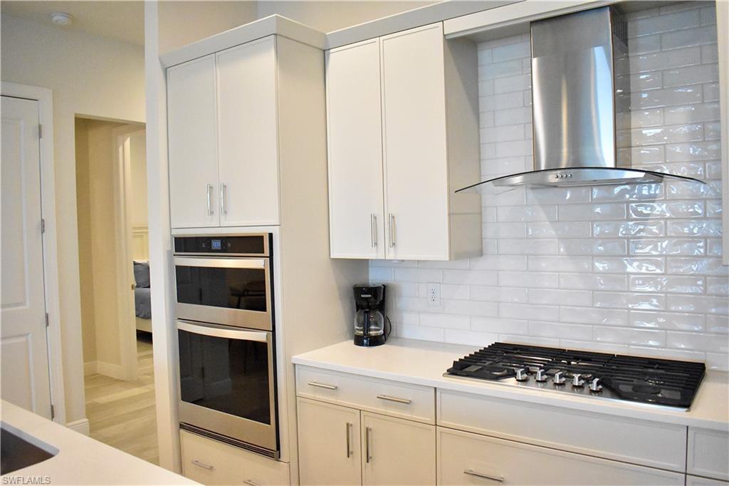 9175 Cayman Drive Naples, FL 34114 - Photo 14 of 31 a kitchen with white cabinets and appliances