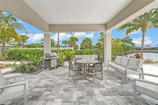 a living room with patio furniture and a floor to ceiling window