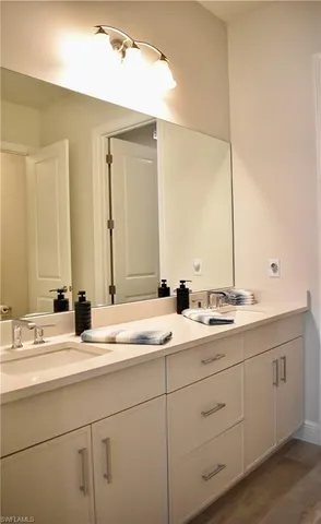 a bathroom with double sink and a mirror