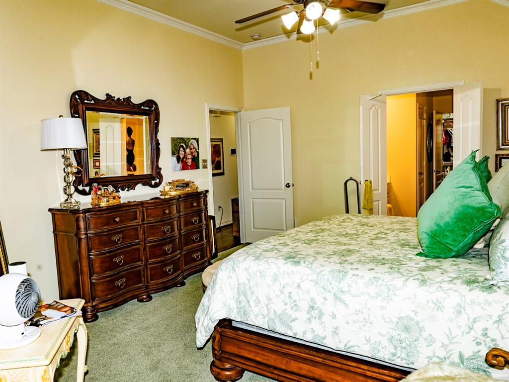 9028 Racquet Club Drive Fort Worth, TX 76120 - Photo 18 of 26 a bedroom with a bed and a chandelier