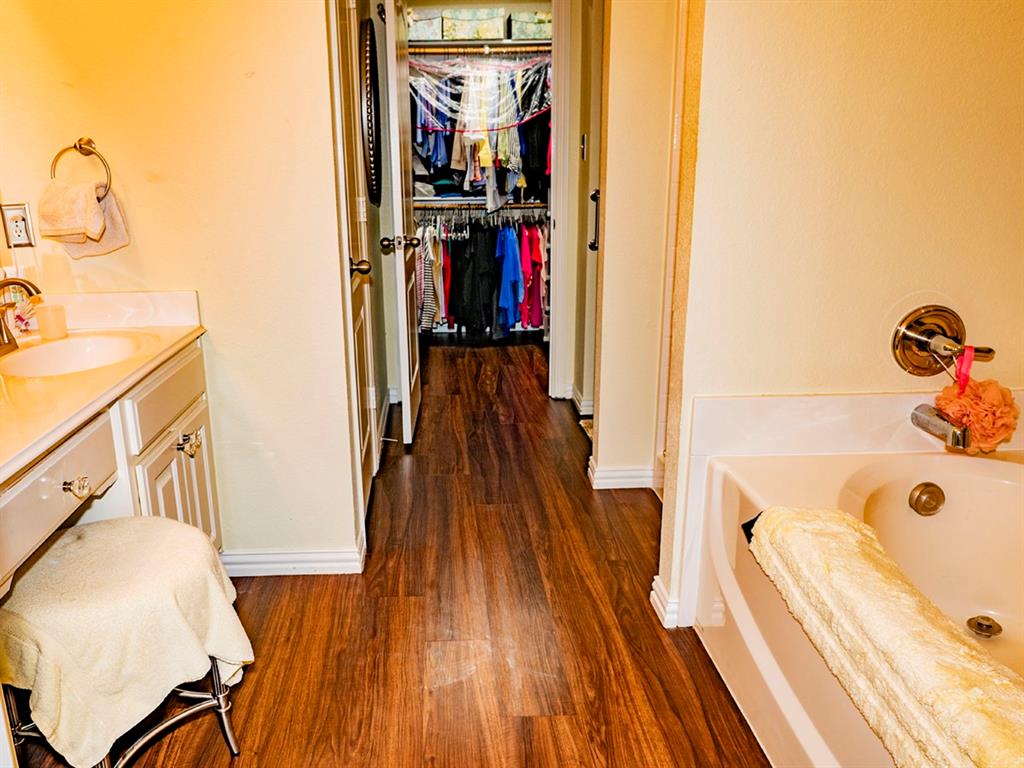 9028 Racquet Club Drive Fort Worth, TX 76120 - Photo 21 of 26 a walk in closet with wooden floor