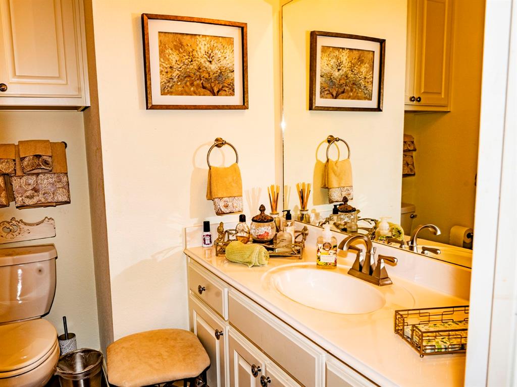 9028 Racquet Club Drive Fort Worth, TX 76120 - Photo 23 of 26 a bathroom with a toilet sink and mirror
