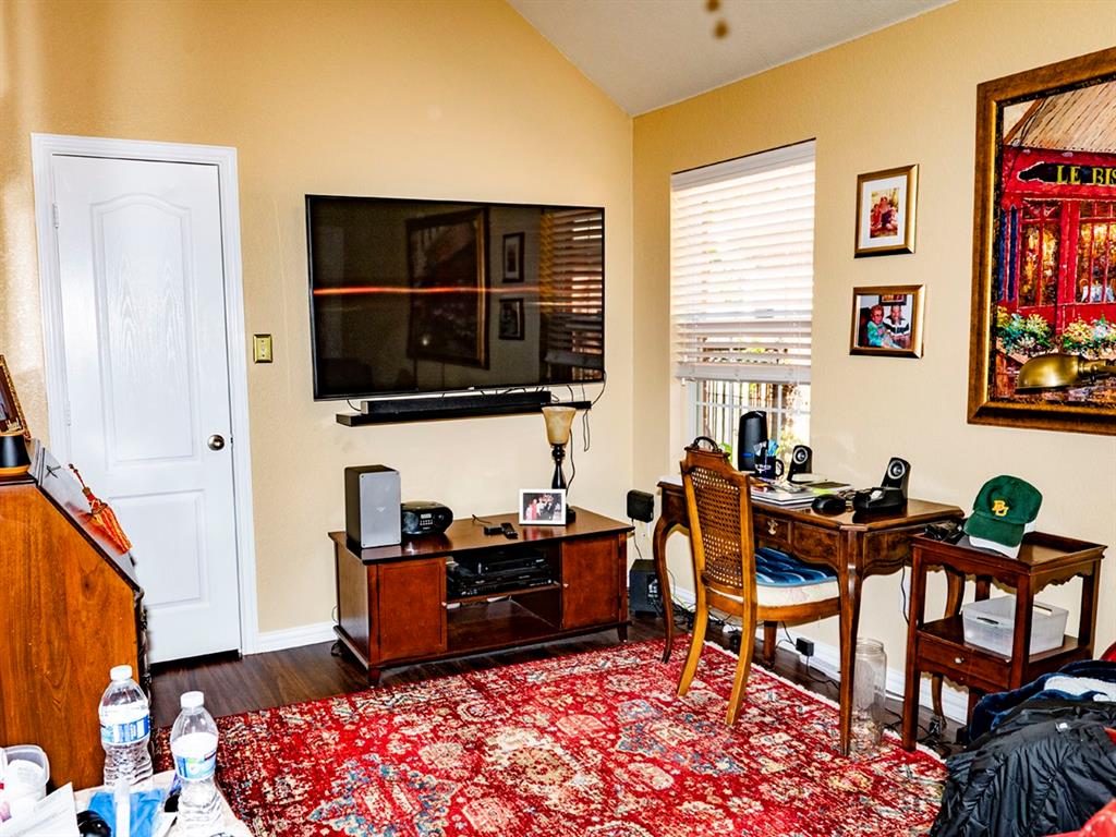9028 Racquet Club Drive Fort Worth, TX 76120 - Photo 24 of 26 a living room with furniture a flat screen tv and a window