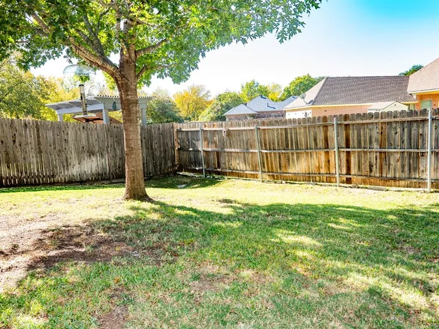a backyard of a house with barbeque oven table and chairs